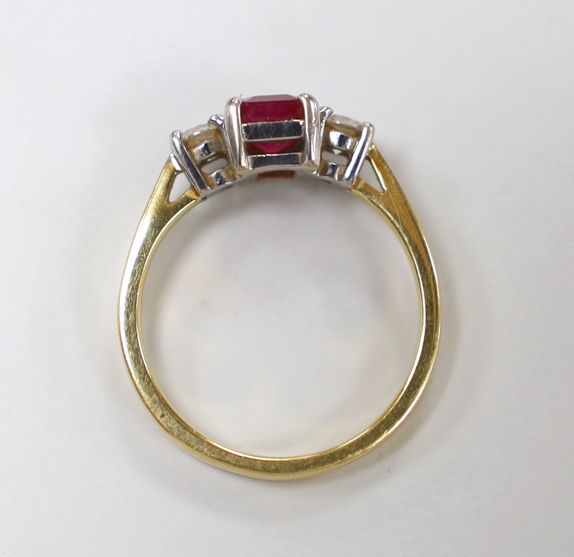 A modern 18ct gold, ruby and diamond set three stone ring, size M/N, gross weight 3.8 grams.